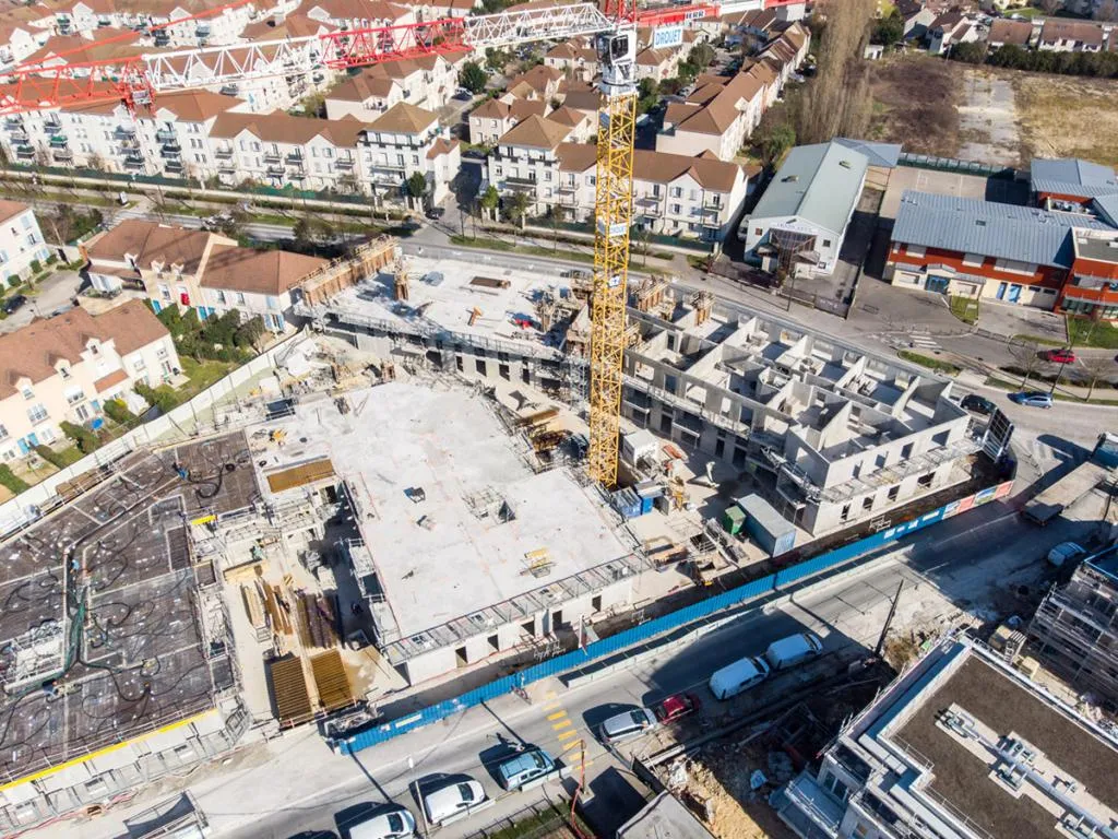 Vue aérienne par drone d'un chantier d'immeuble avec grue